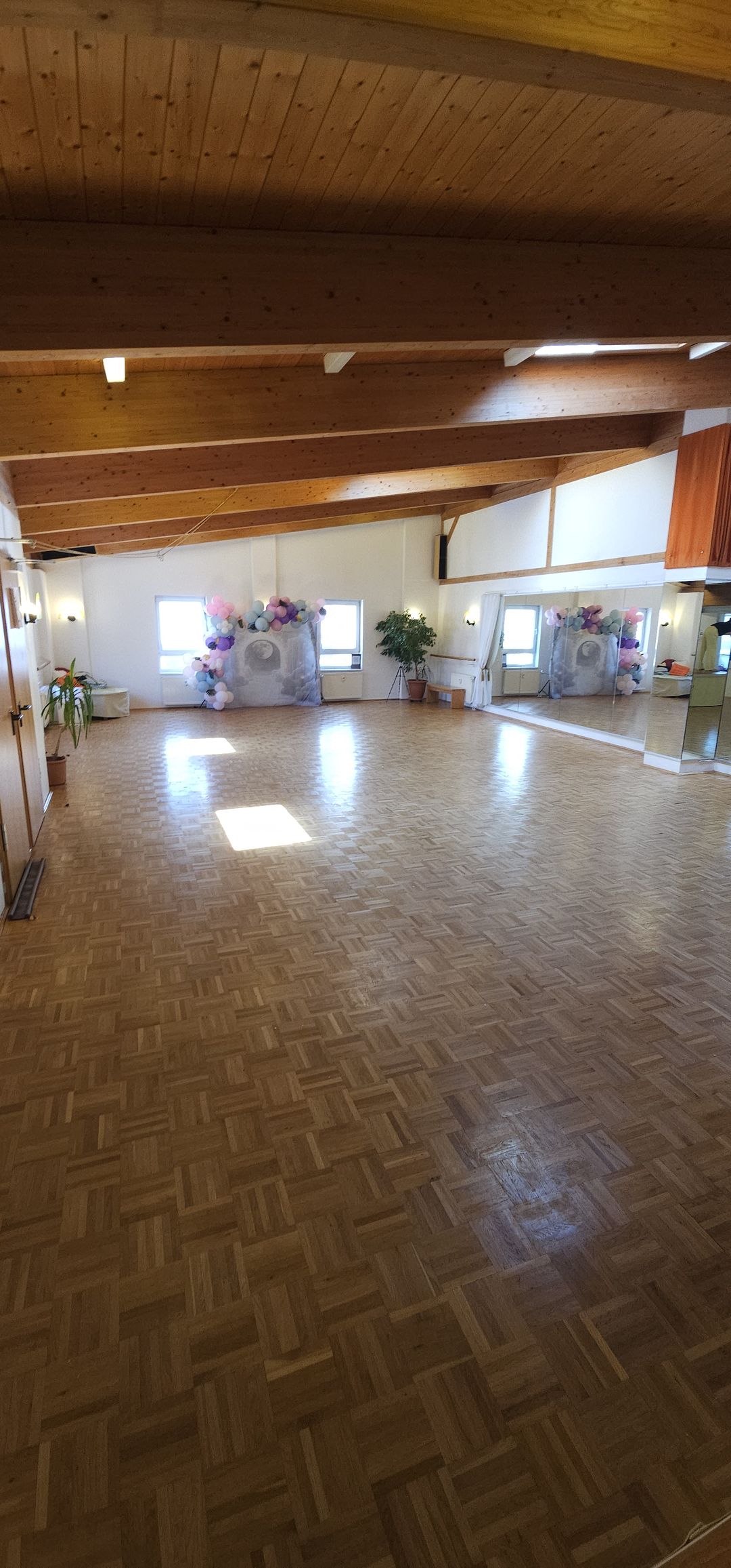 Der 140 m² große säulenfreie Tanzsaal in Nürnberg mit Holzbalkendecke, Spiegelwand und Fensterfront